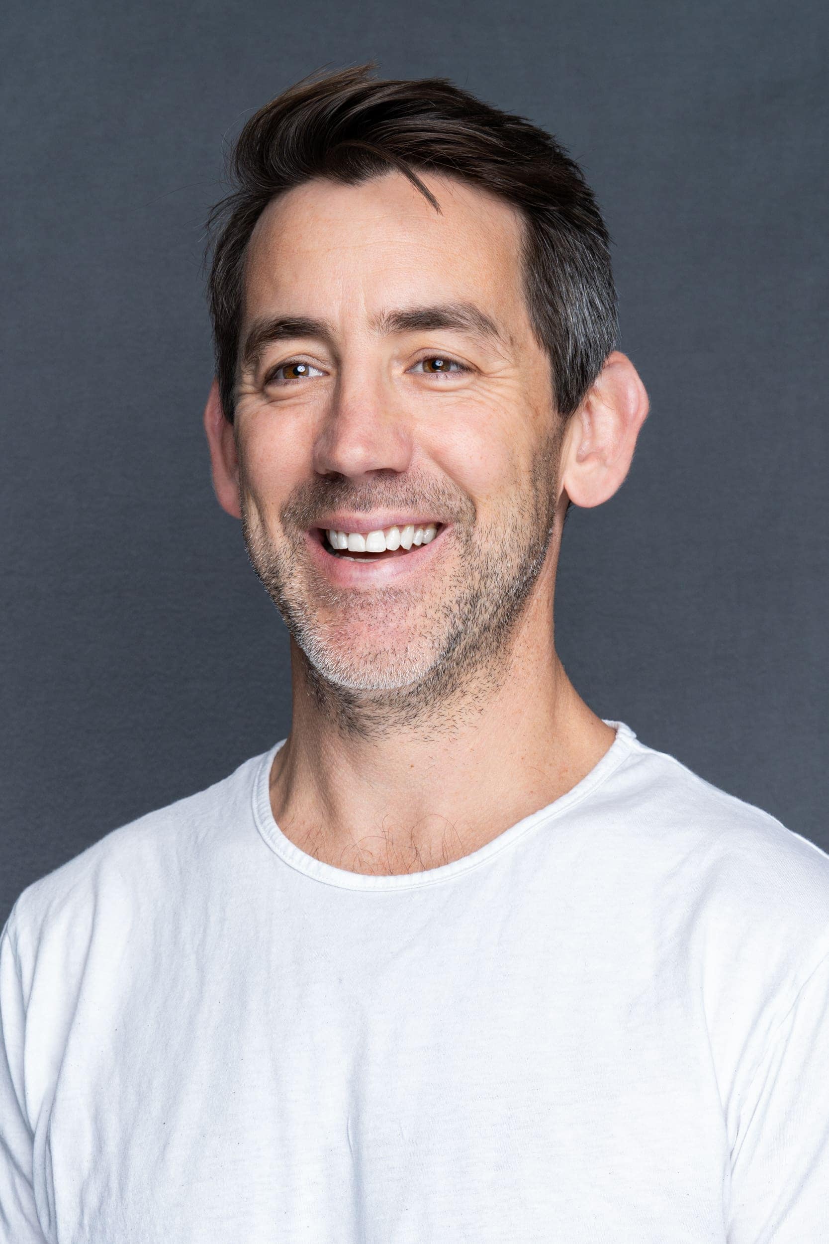 Male-CEO-Headshot-Sydney-NSW Int: man with dark hair in a white t-shirt having a head shot taken by Sydney Headshot Photographer Georgie Greene in Sydney NSW
