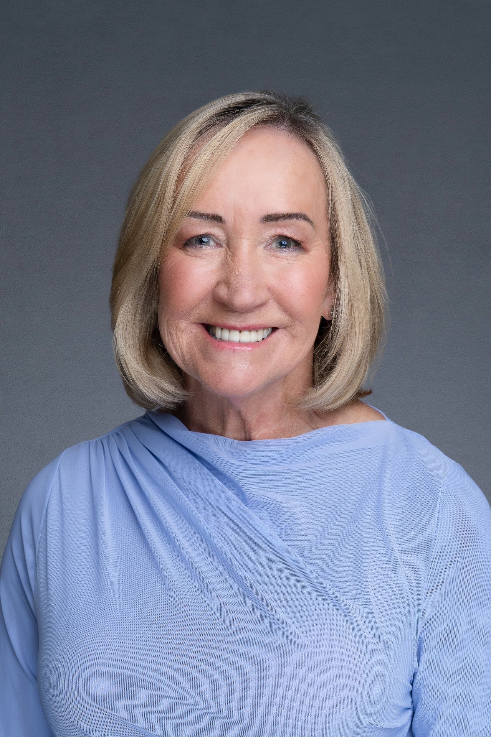 Female CEO wearing a blue shirt and having her LinkedIn headshot taken by Sydney corporate photographer Georgie Greene