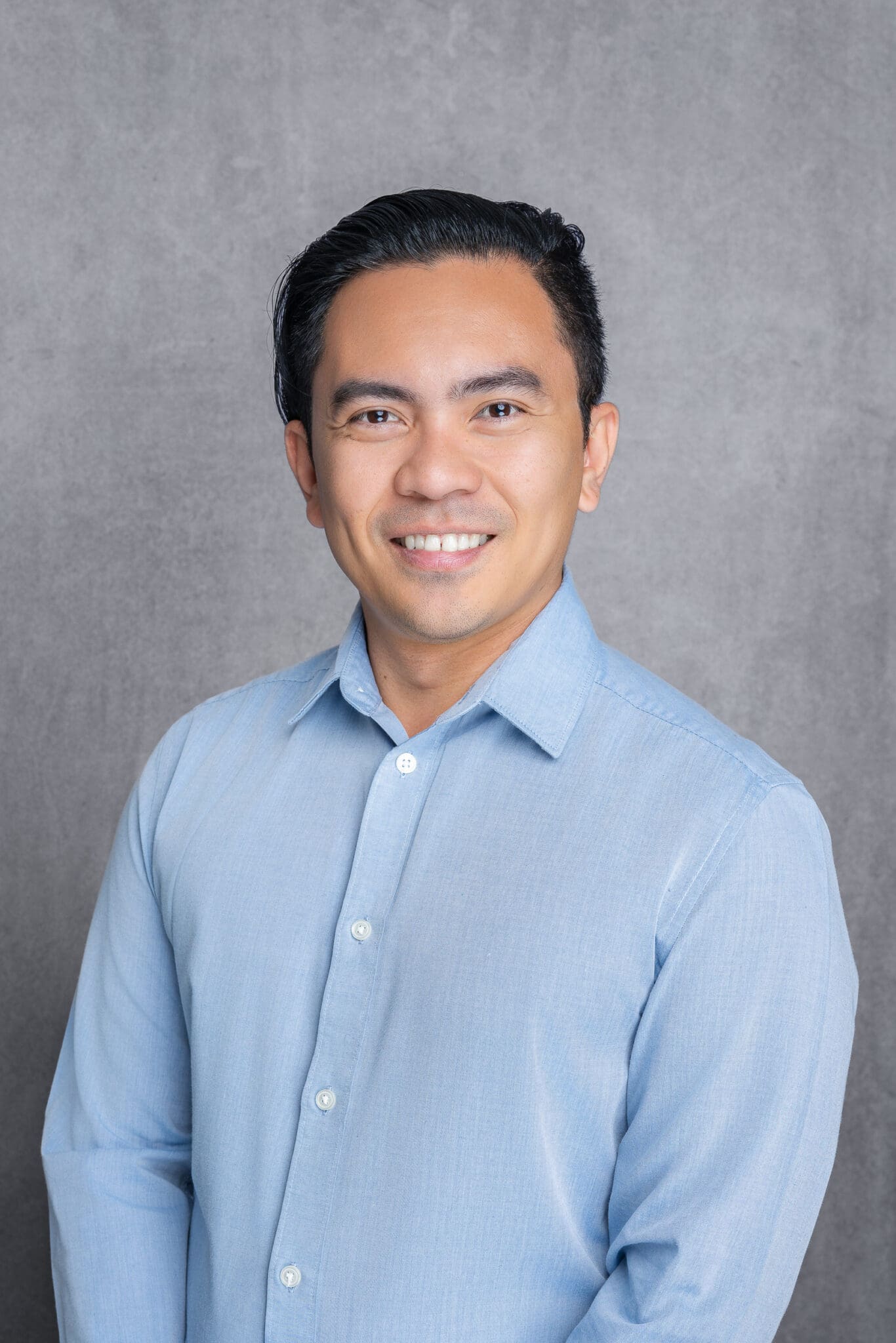 Young Asian man wearing a blue shirt having his headshot taken by Sydney professional photographer Georgie Greene