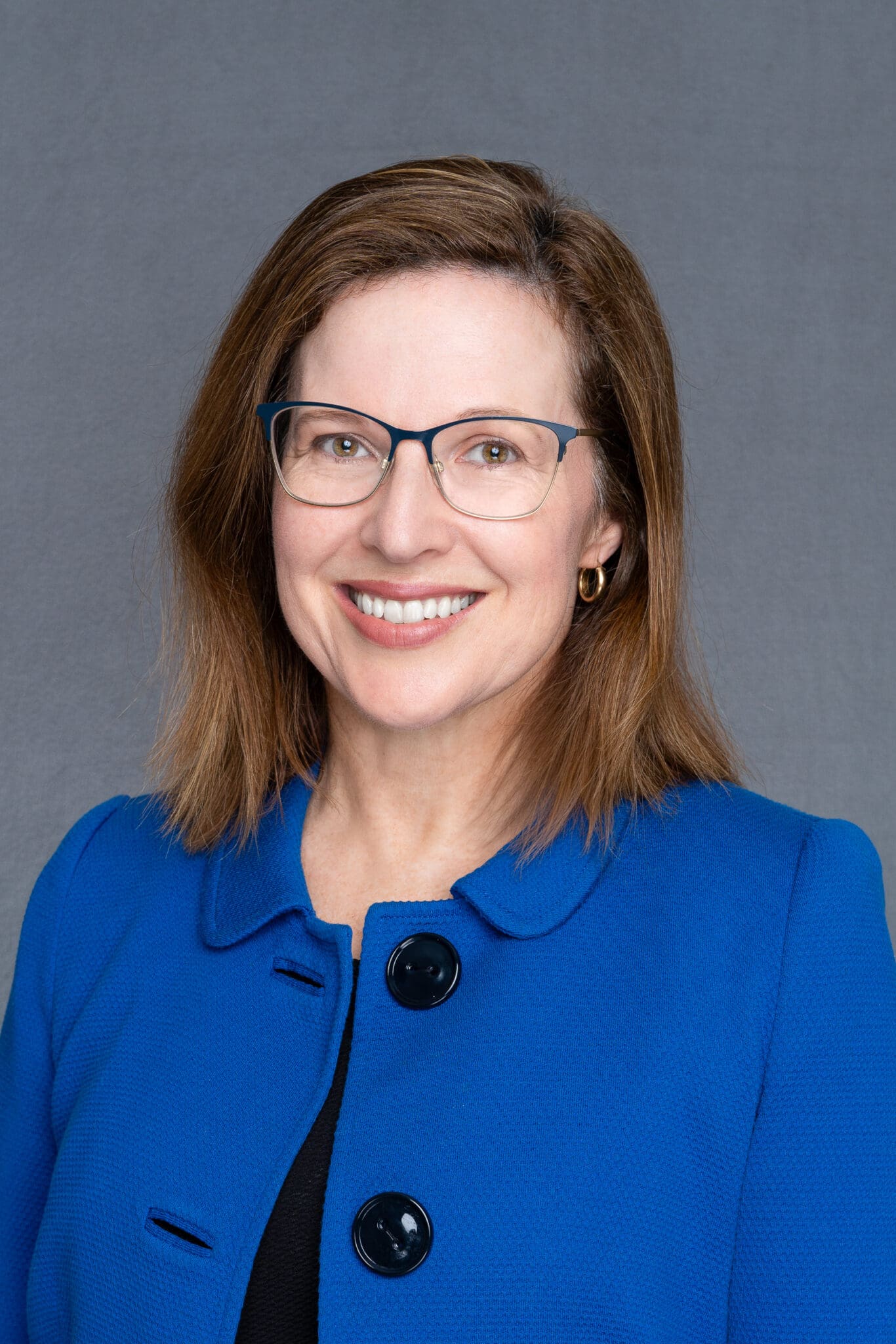 Middle-aged woman wearing a blue jacket having her LinkedIn headshot taken by Sydney personal branding LinkedIn photographer Georgie Greene