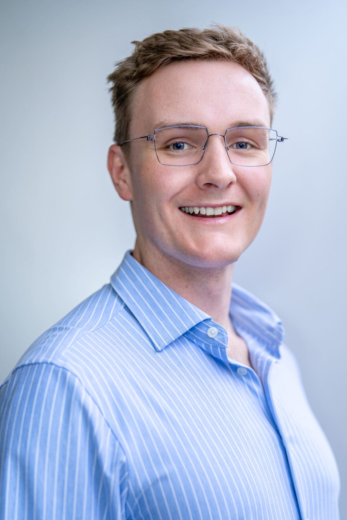 Young blonde Doctor wearing a blue shirt having his headshot taken by Sydney photographer Georgie Greene