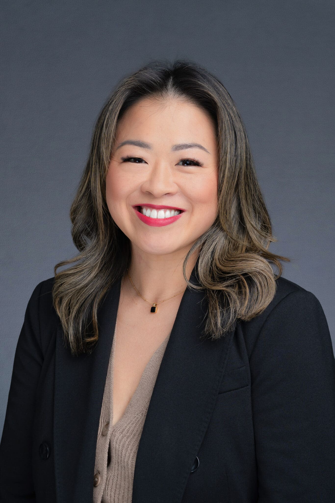 Young Asian woman wearing a black coat having her headshot taken by Sydney headshot photographer Georgie Greene