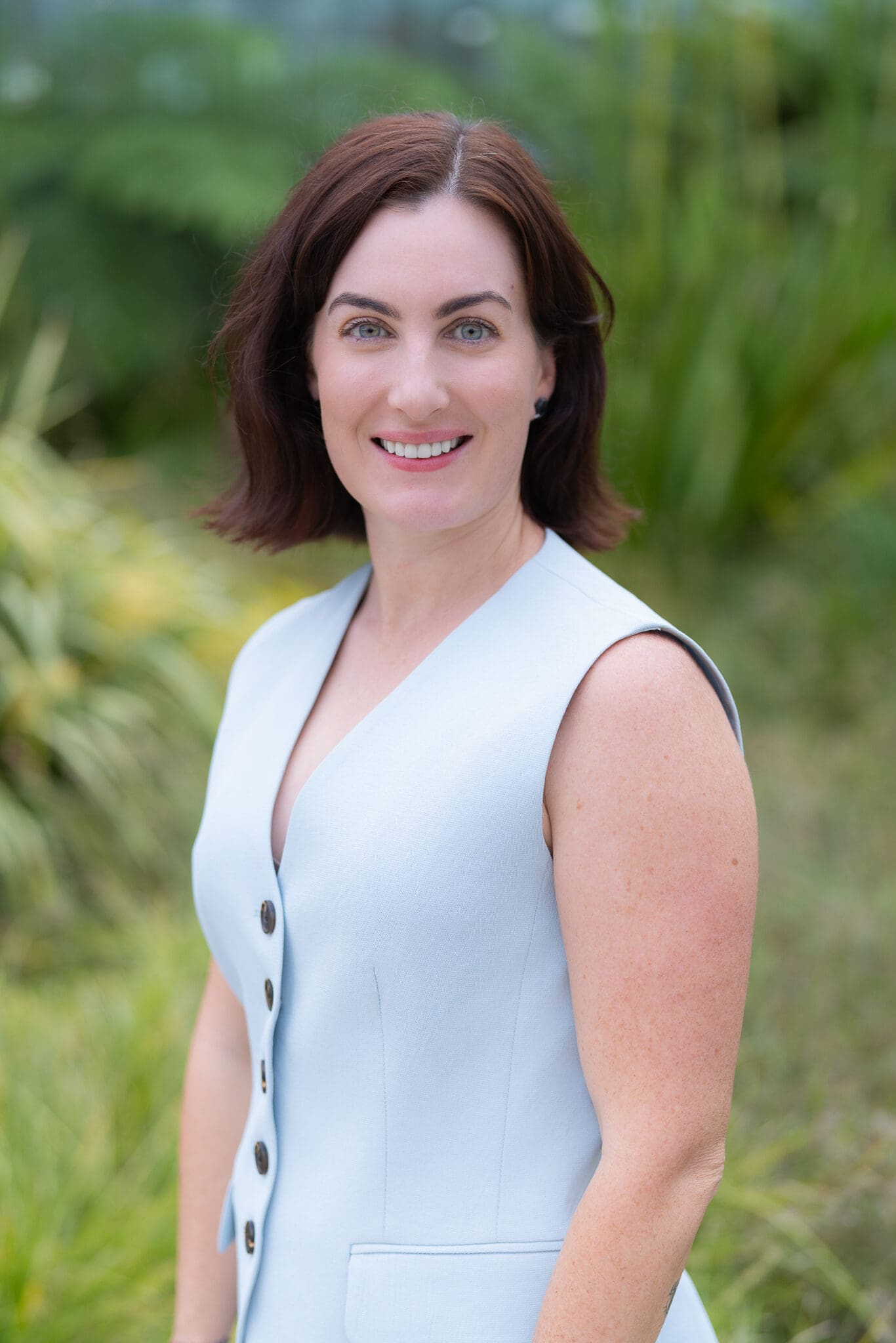 Young dark haired woman wearing a blue top having her headshot taken by Sydney portrait photographer Georgie Greene