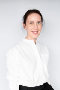 Young dark haired woman wearing white shirt and having her natural light headshot taken by top Sydney headshot photographer Georgie Greene