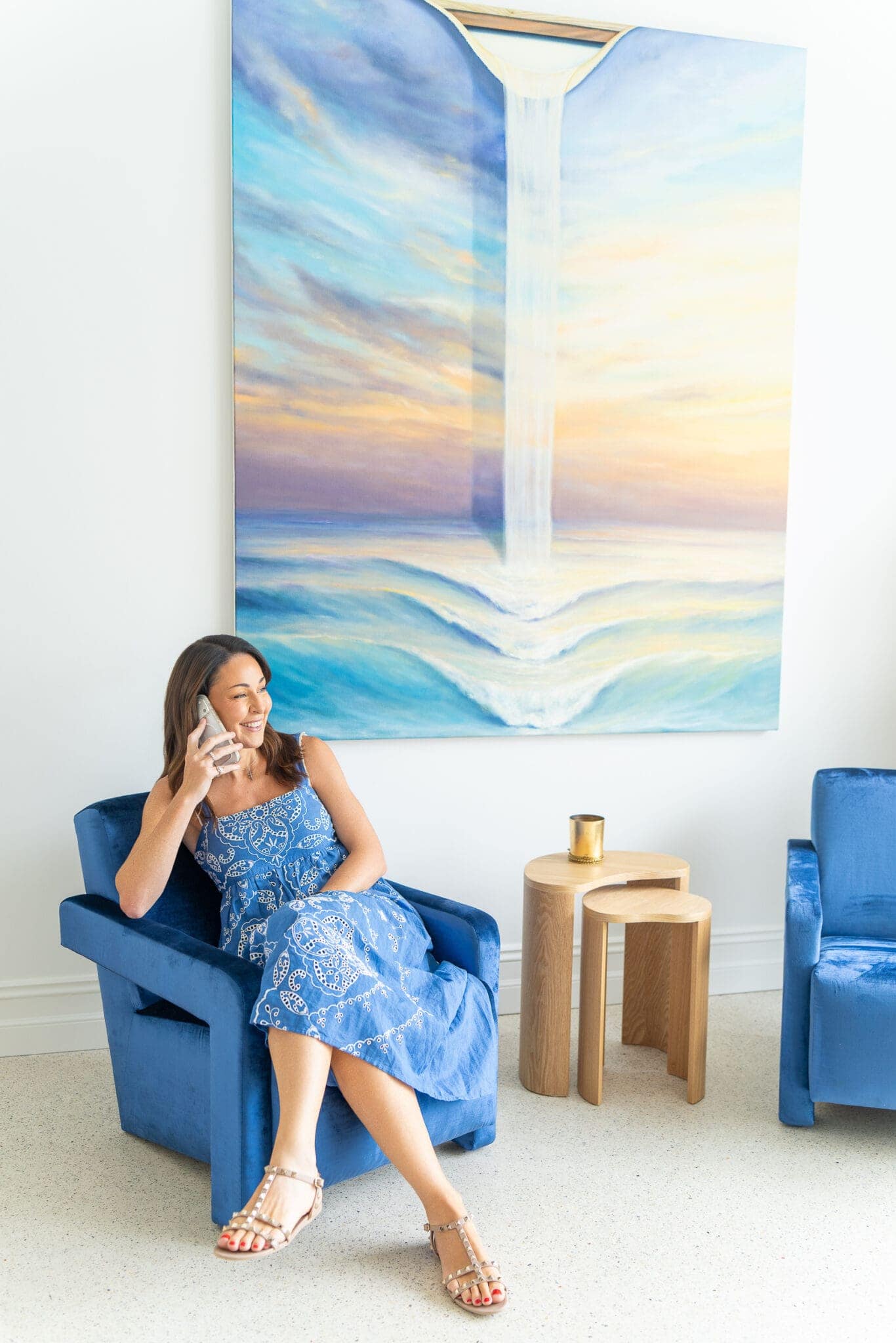 dark haired marketing specialist sitting on a blue chair on the phone having her personal branding photo taken by professional Sydney photographer Georgie Greene