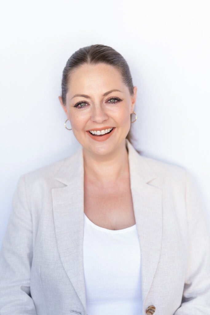 smiling young woman in a beige jacket having her personal branding portrait taken by Sydney portrait photographer Georgie Greene
