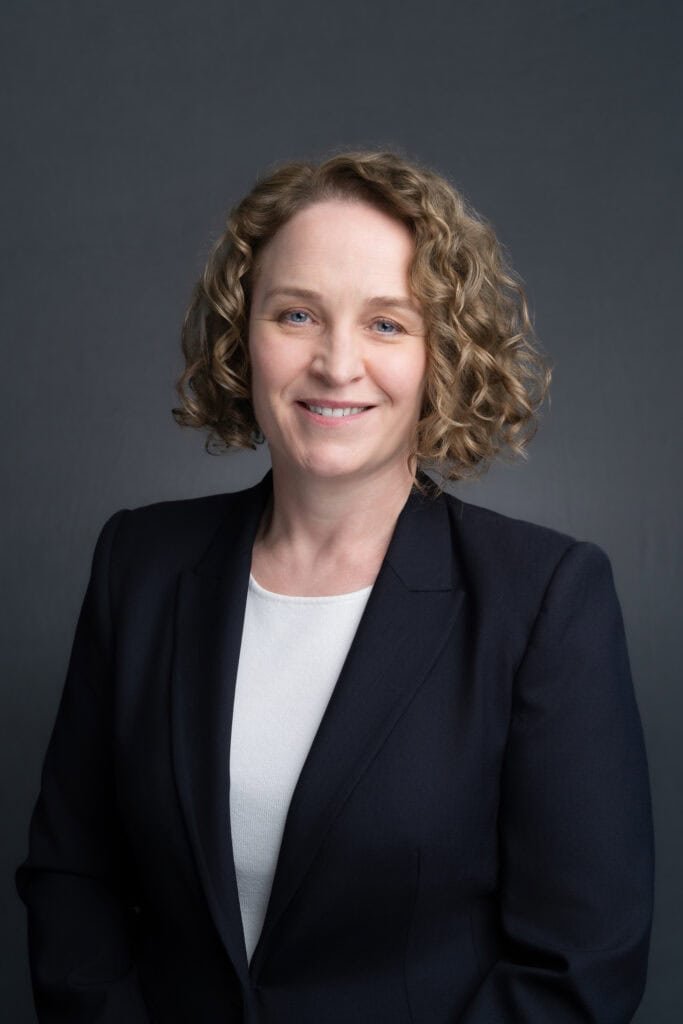 Woman with blond curly hair having her corporate headshot taken by sydney professional photographer Georgie Greene