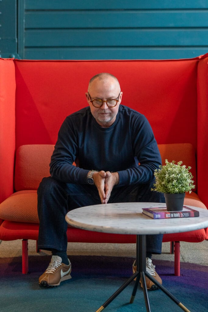 man in a red chair having his personal branding portrait taken by professional photographer Georgie Greene