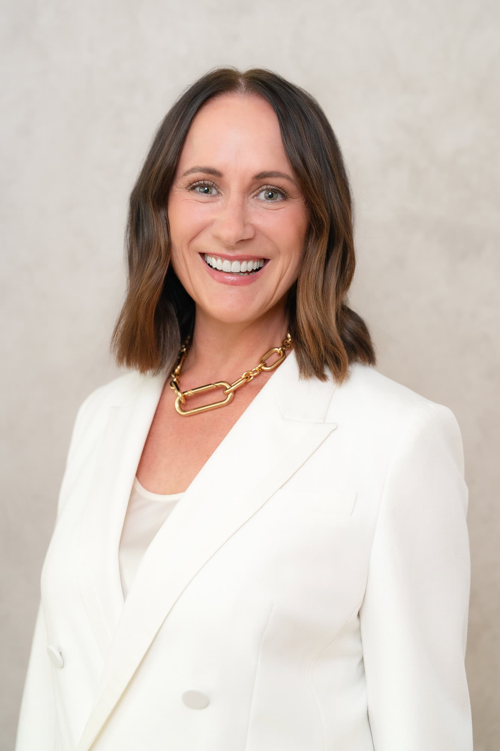 Sydney-Headshots Young brunette woman wearing a white suit having her headshot taken by Sydney professional photographer Georgie Greene