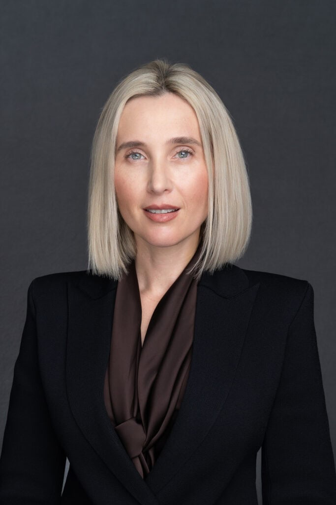 blonde woman in a black jacket having her professional headshot taken by headshot photographer Georgie Greene