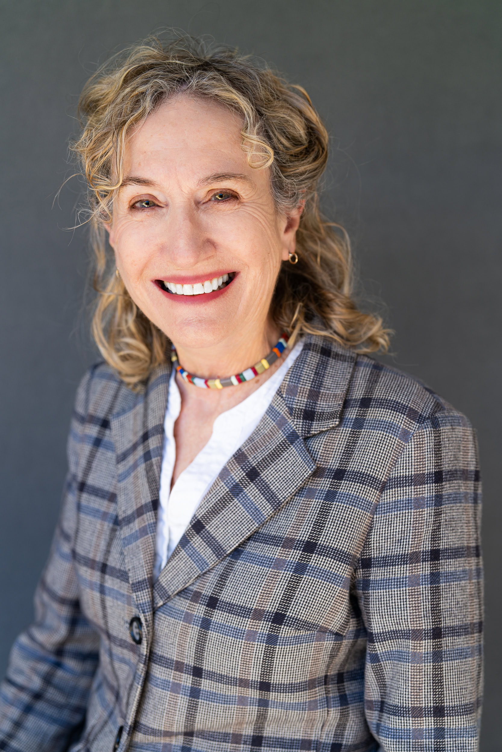 Solicitor-Headshot-Sydney older blonde solicitor in a checked suit having her headshot taken by professional headshot photographer Georgie Greene