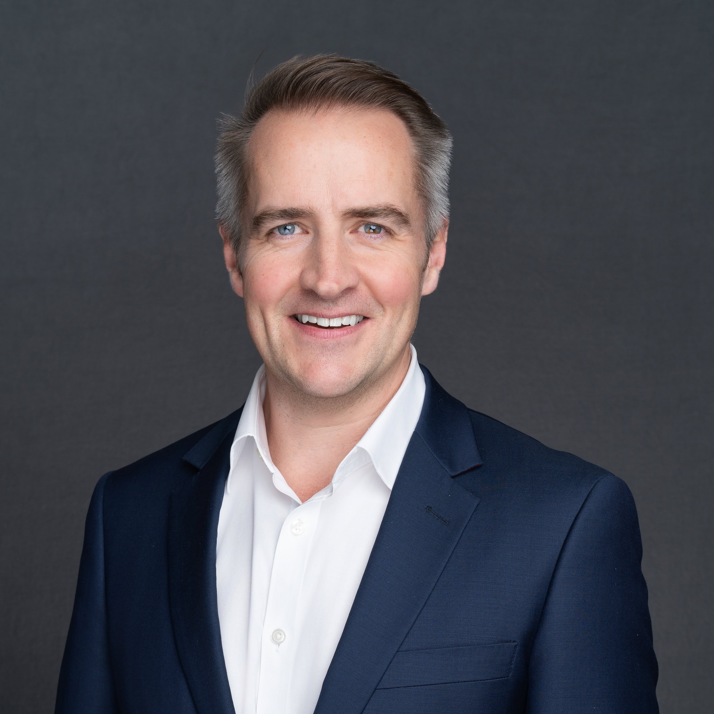 grey haired man with a blue jacket having his corporate headshot taken by professional photographer Georgie Greene