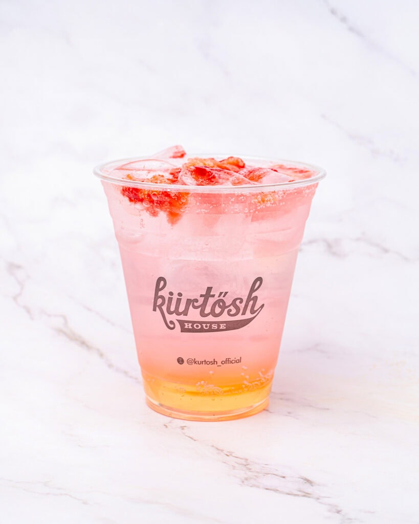 Pink soft drink made by Kurtosh in a plastic cup