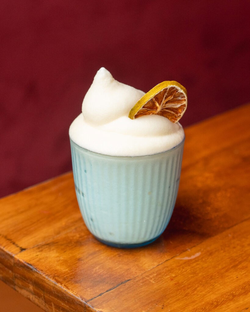 Japanese drink with white foam and a dried orange