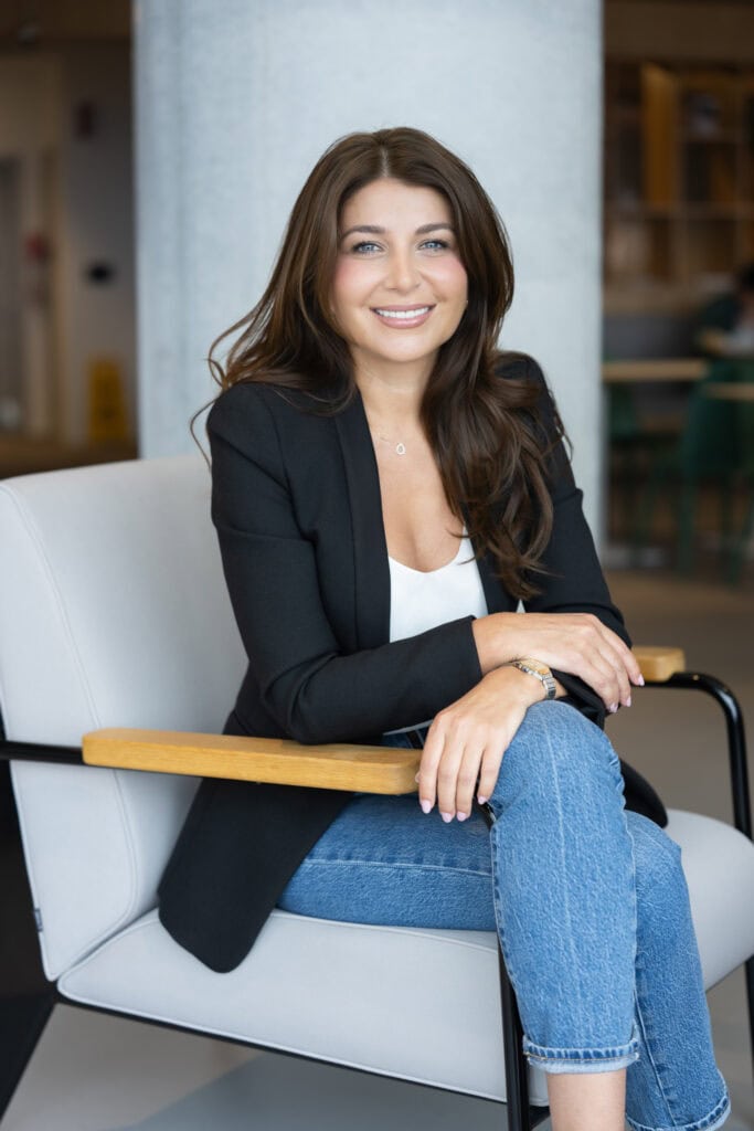 dark haired lawyer sitting in a chair having her branding portrait taken by professional headshot photographer Georgie Greene